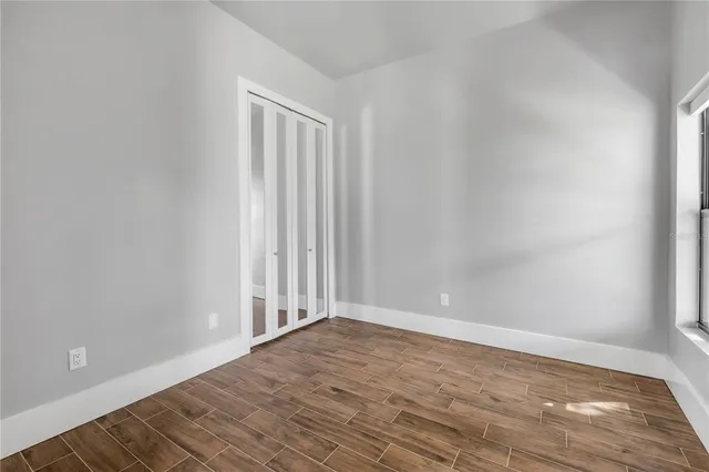 a view of a hallway with wooden floor and windows