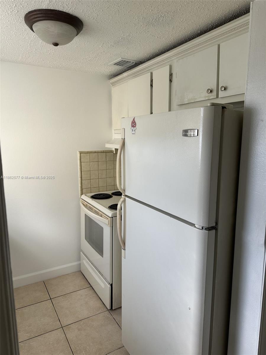 8600 Southwest 109th Avenue, Unit 4216 Miami, FL 33173 - Photo 11 of 20 a white refrigerator freezer and a stove sitting inside of a kitchen
