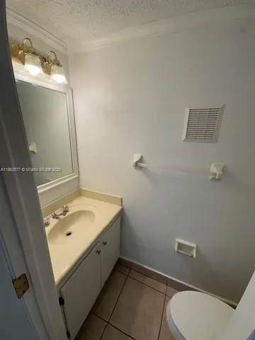 a bathroom with a granite countertop sink a toilet and mirror
