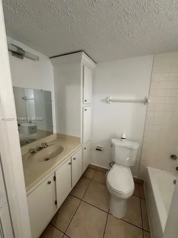 a bathroom with a granite countertop toilet and a sink