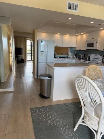 a kitchen with stainless steel appliances granite countertop a refrigerator a stove a sink dishwasher with a dining table and chairs