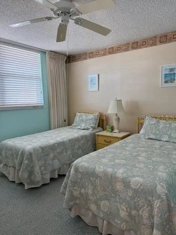 a bedroom with two bed and window