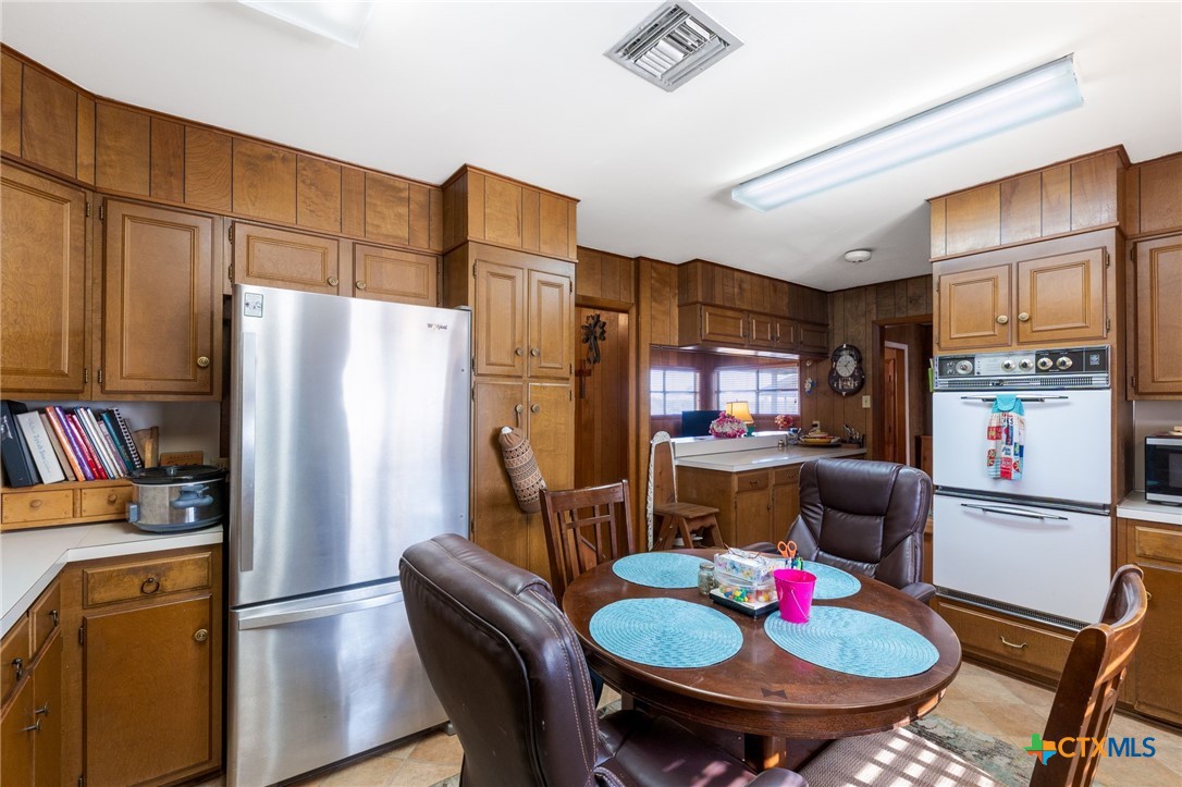 1003 North Ridge Street Lampasas, TX 76550 - Photo 13 of 44 a kitchen with stainless steel appliances granite countertop a dining table and chairs