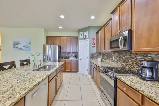 a kitchen with stainless steel appliances granite countertop a table and chairs