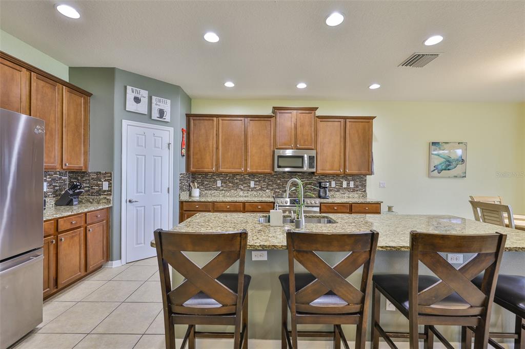 1516 Yale Castle Court Ruskin, FL 33570 - Photo 13 of 52 a kitchen with stainless steel appliances granite countertop a table and chairs