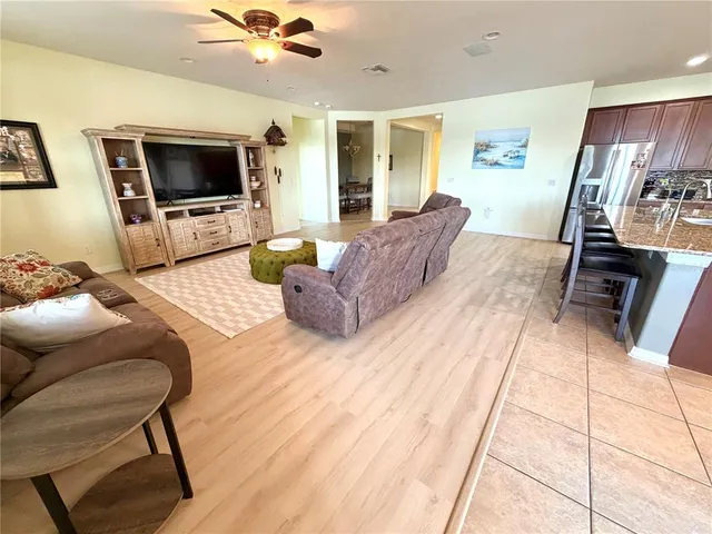 a living room with furniture kitchen and a wooden floor