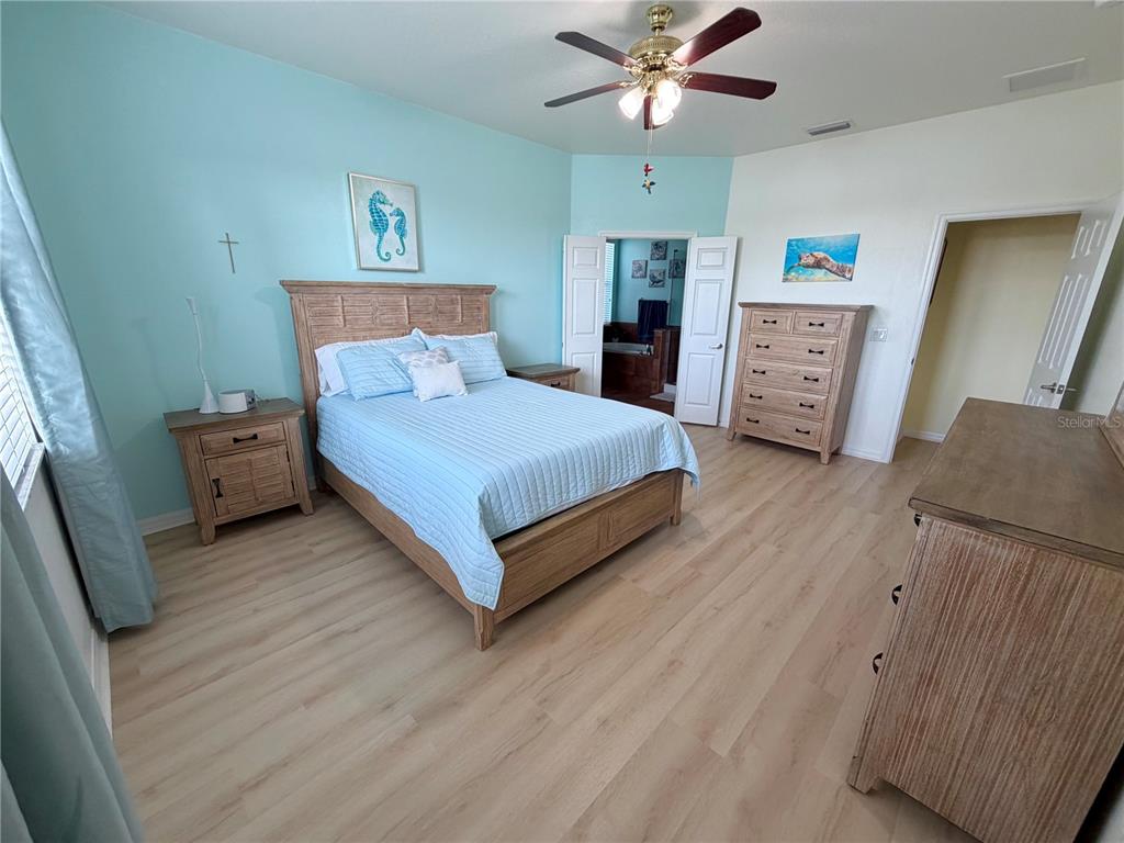 1516 Yale Castle Court Ruskin, FL 33570 - Photo 26 of 52 a spacious bedroom with a bed and a chandelier