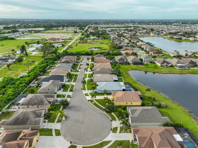 an aerial view of residential houses with outdoor space and lake view