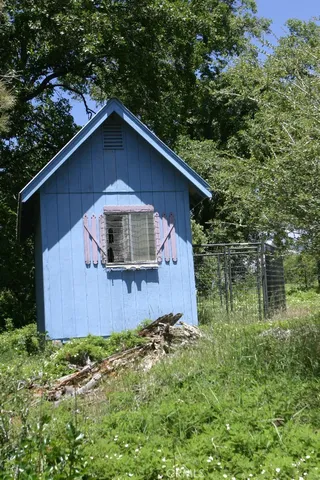 a view of dirt yard with a house