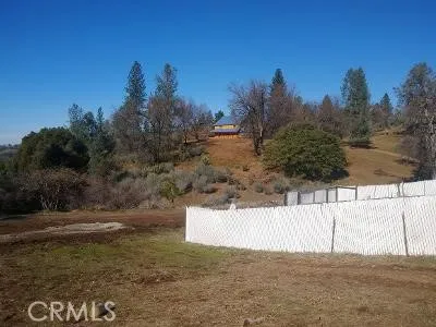 a view of a brick house with wooden fence