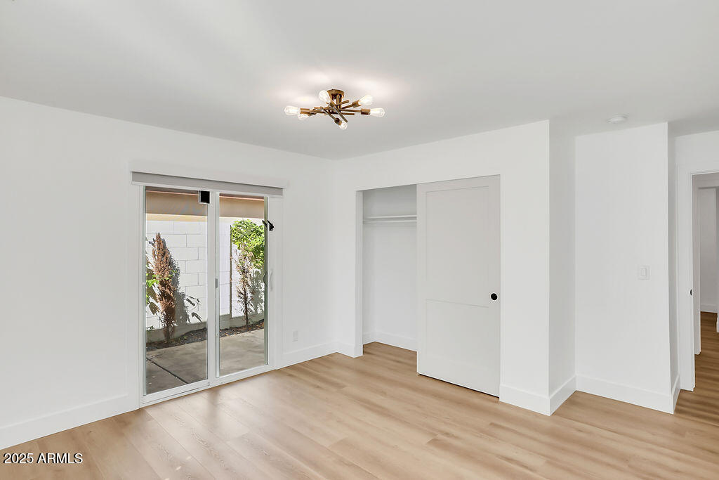 4102 East Pinchot Avenue Phoenix, AZ 85018 - Photo 11 of 28 a view of an empty room with wooden floor and a window
