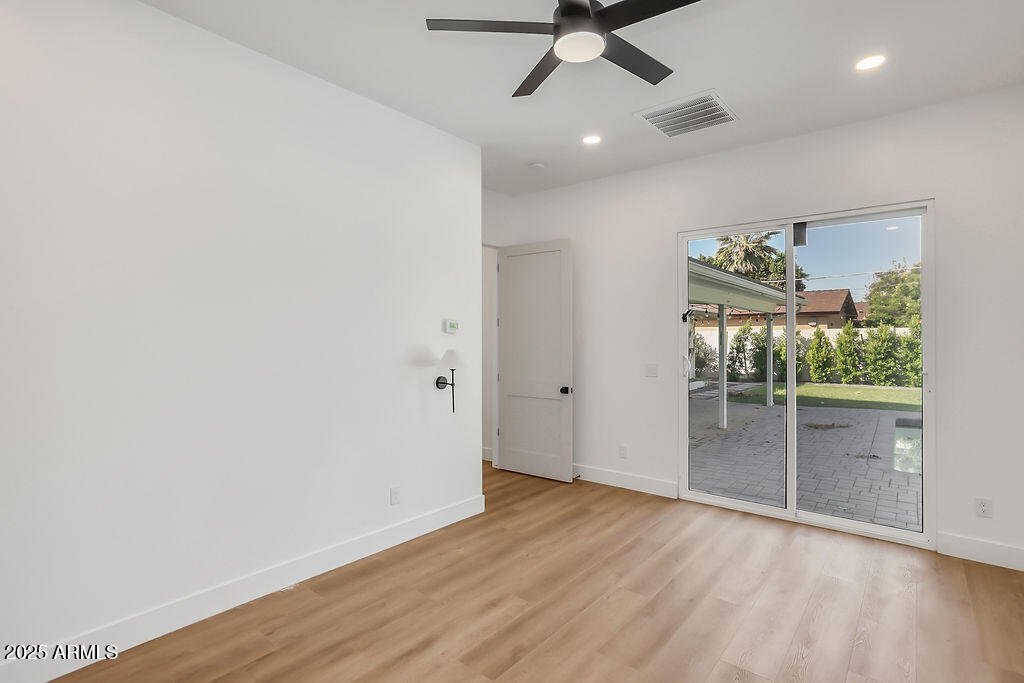 4102 East Pinchot Avenue Phoenix, AZ 85018 - Photo 12 of 28 an empty room with wooden floor fan and windows