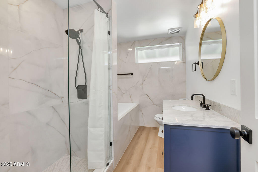 4102 East Pinchot Avenue Phoenix, AZ 85018 - Photo 19 of 28 a bathroom with a sink a mirror a vanity and shower