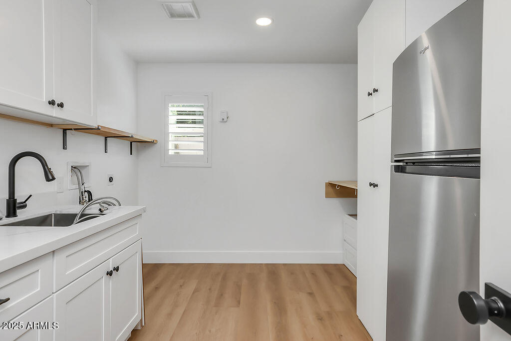 4102 East Pinchot Avenue Phoenix, AZ 85018 - Photo 21 of 28 a kitchen with a refrigerator and cabinets