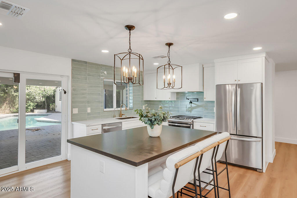 4102 East Pinchot Avenue Phoenix, AZ 85018 - Photo 3 of 28 a kitchen with stainless steel appliances granite countertop a sink and a refrigerator