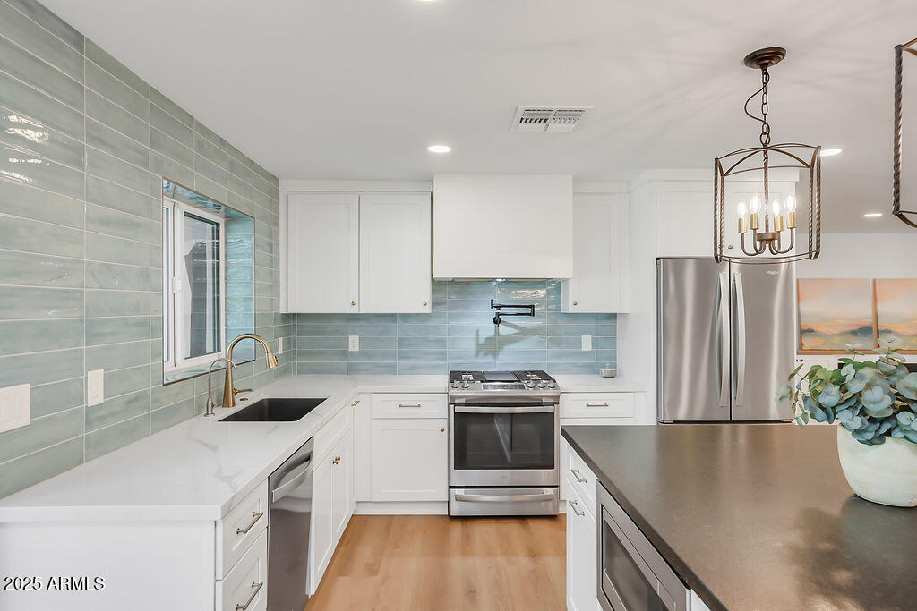 4102 East Pinchot Avenue Phoenix, AZ 85018 - Photo 4 of 28 a kitchen that has a lot of cabinets a sink and a stove