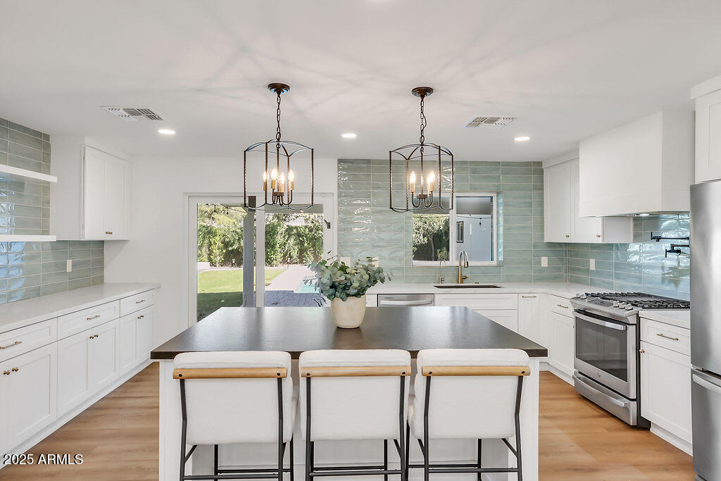 4102 East Pinchot Avenue Phoenix, AZ 85018 - Photo 5 of 28 a kitchen with a dining table chairs sink and stove top oven