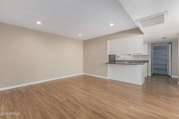 a view of a kitchen with a sink and dishwasher a refrigerator with wooden floor