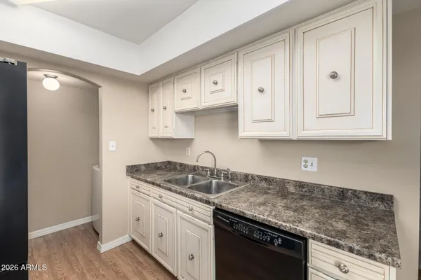 a kitchen with granite countertop white cabinets and a sink