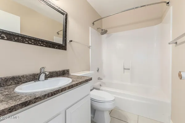 a bathroom with a granite countertop sink mirror vanity and toilet