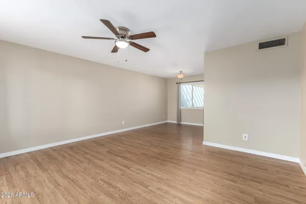 an empty room with wooden floor and windows