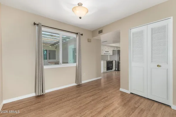 an empty room with wooden floor and windows