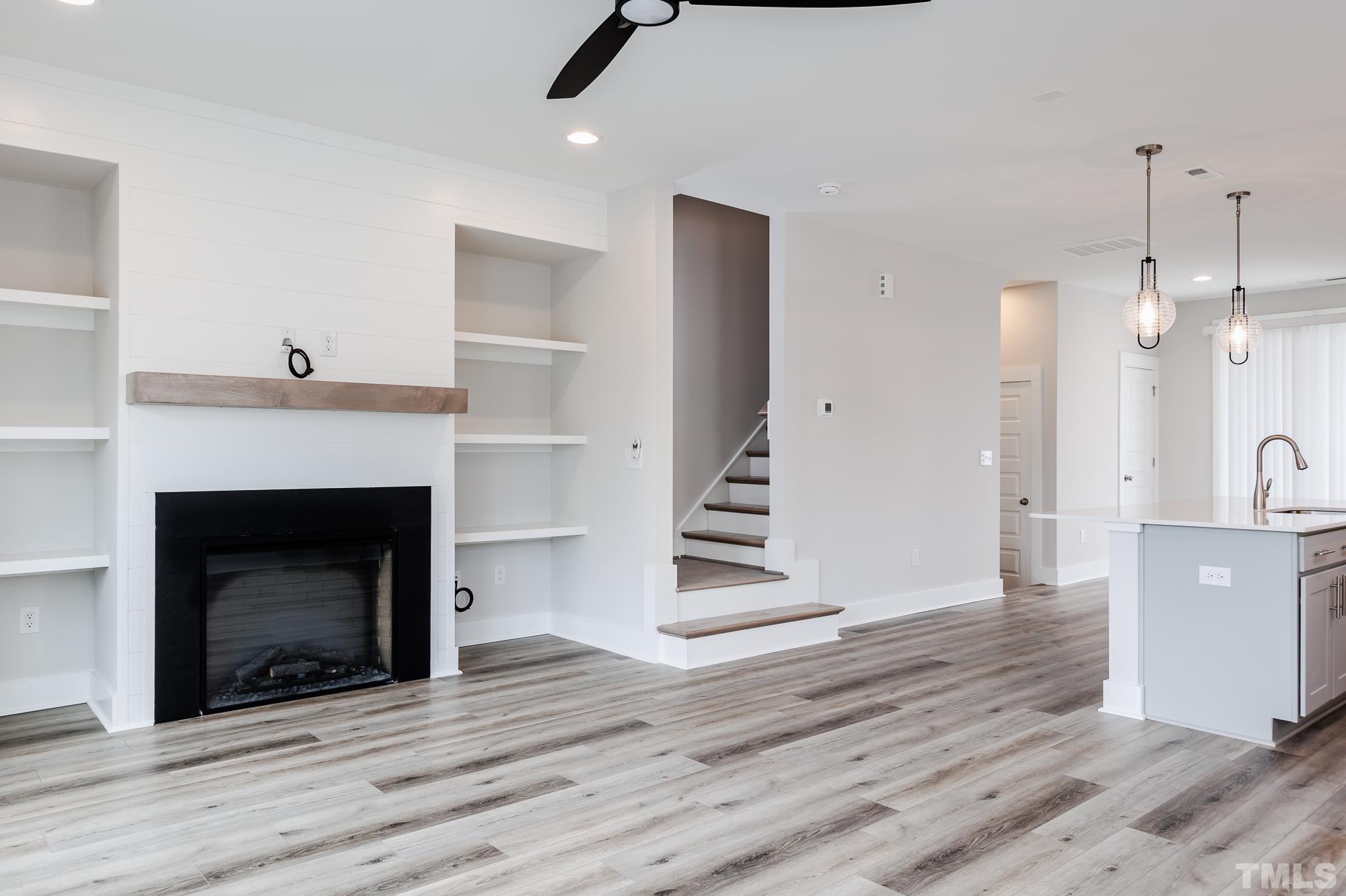 8226 Ebenezer Church Road Raleigh, NC 27613 - Photo 5 of 16 a view of a livingroom with wooden floor and a fireplace