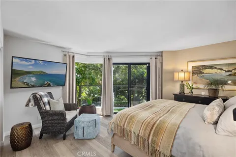 a bedroom with bed and a painting on the wall