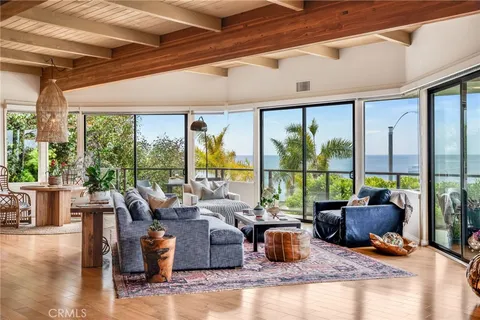 a living room with furniture tv and large windows