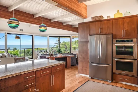 a kitchen with stainless steel appliances granite countertop a refrigerator a sink and a stove