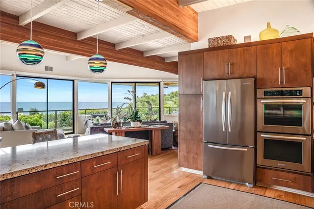 a kitchen with stainless steel appliances granite countertop a refrigerator a sink and a stove