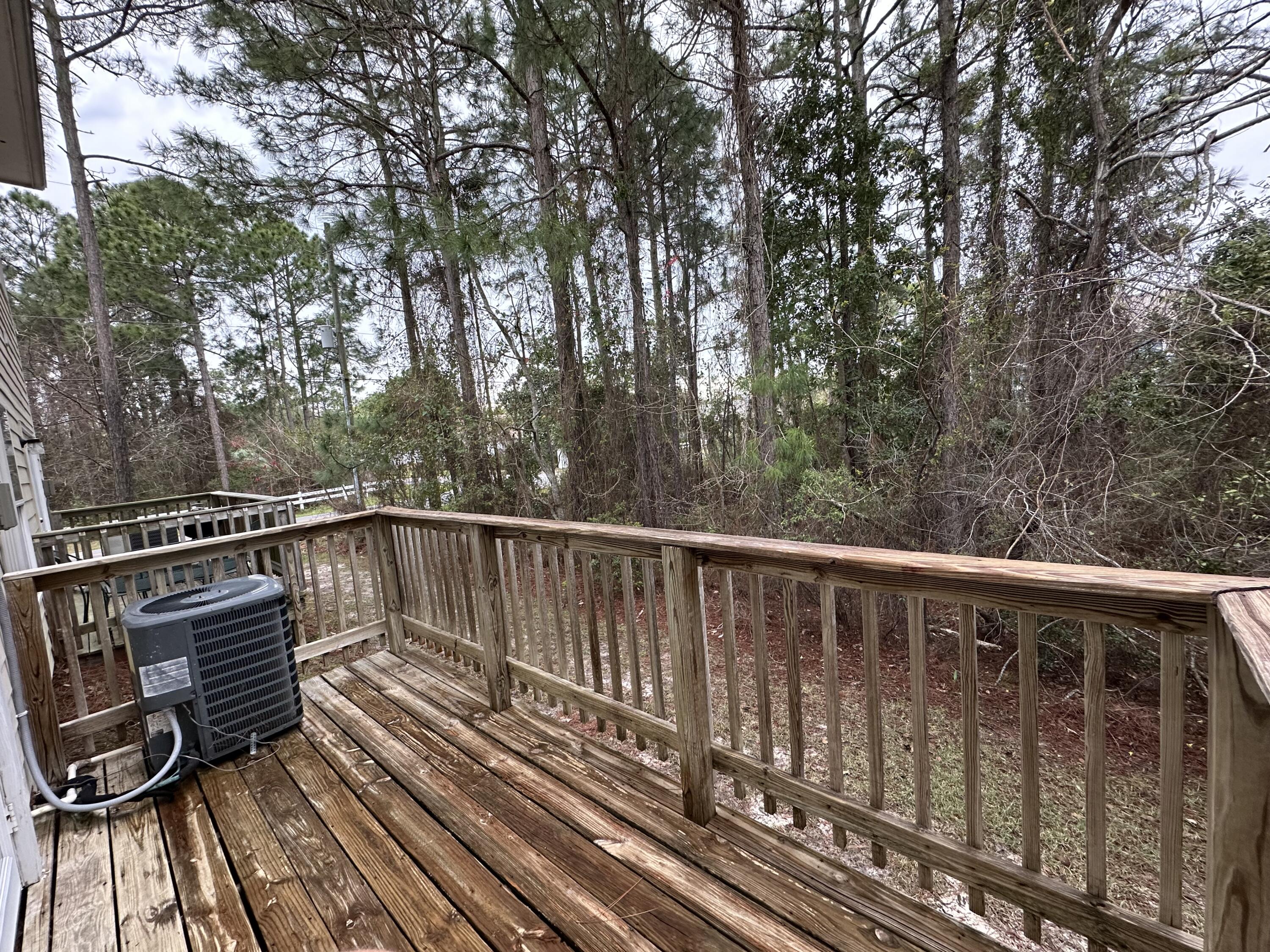 732 East Mack Bayou Drive, Unit 2 Santa Rosa Beach, FL 32459 - Photo 36 of 43 a balcony with wooden floor and trees in the back
