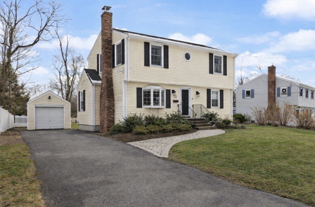 50 Forest Street Reading, MA 01867 - Photo 1 of 42 a front view of a house with a garden and yard