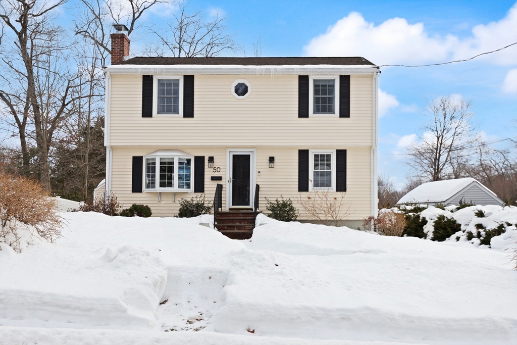 50 Forest Street Reading, MA 01867 - Photo 3 of 42 a front view of a house with a yard covered in snow