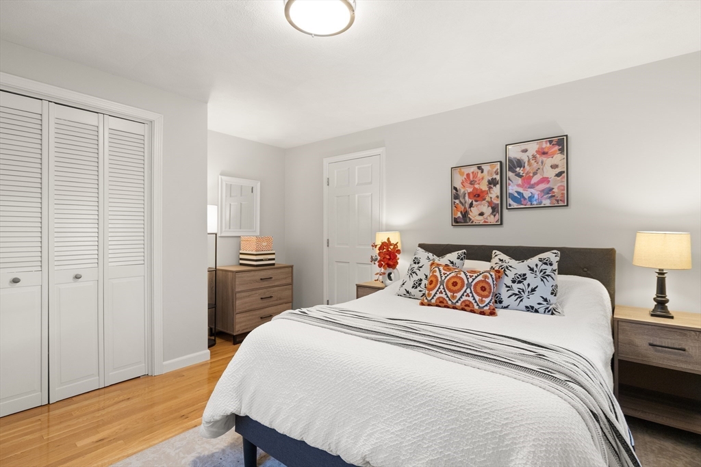 50 Forest Street Reading, MA 01867 - Photo 32 of 42 a bedroom with a bed and a lamp on dresser
