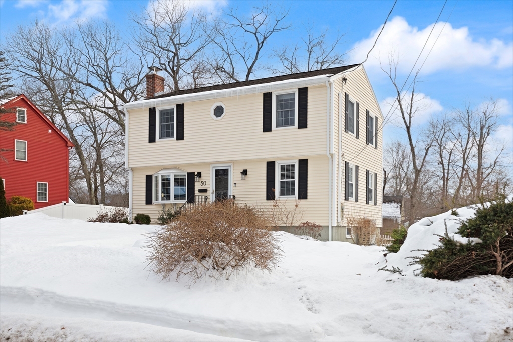 50 Forest Street Reading, MA 01867 - Photo 4 of 42 a front view of a house with a yard covered in snow