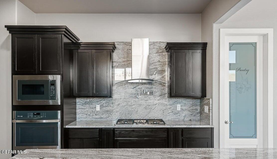 7353 Cimarron Rim Road El Paso, TX 79911 - Photo 9 of 30 a kitchen with kitchen island granite countertop a refrigerator and a stove top oven