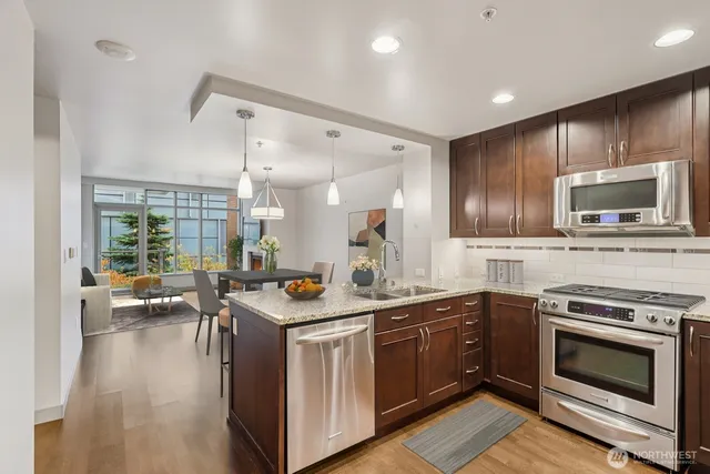 a kitchen with stainless steel appliances a stove sink microwave and cabinets