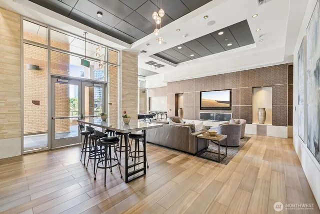 a living room with couches and a dining table with large windows