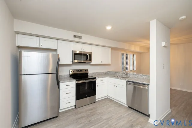 a kitchen with stainless steel appliances a refrigerator sink and microwave