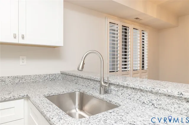 a close view of a sink and a kitchen with granite countertop a sink