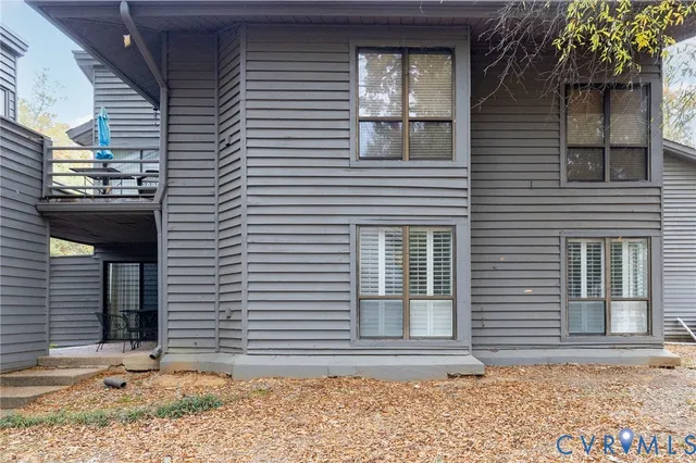 a side view of a house with a yard and sitting area