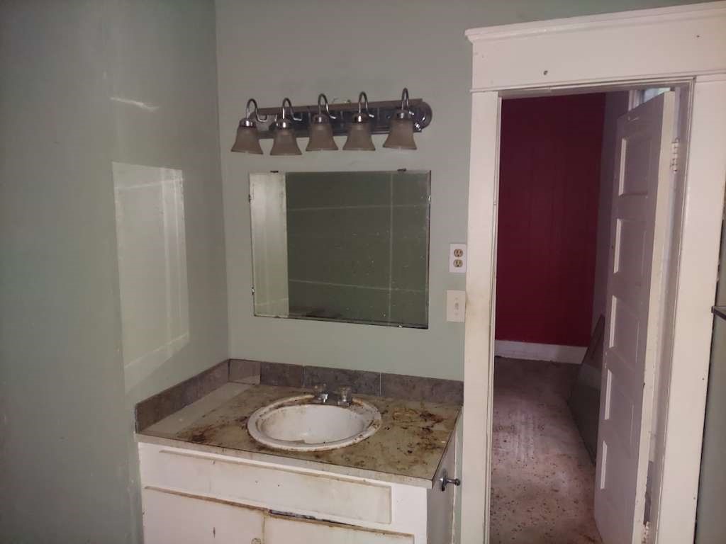404 North Frazier Street Daingerfield, TX 75638 - Photo 8 of 12 a bathroom with a sink vanity and mirror