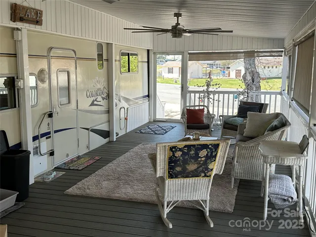 a living room with furniture large window and wooden floor