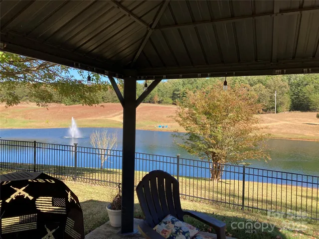 a view of a roof deck with wooden fence and a couple of chairs
