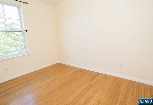 199 Van Winkle Street, Unit 2 East Rutherford, NJ 07073 - Photo 14 of 22 an empty room with wooden floor and windows