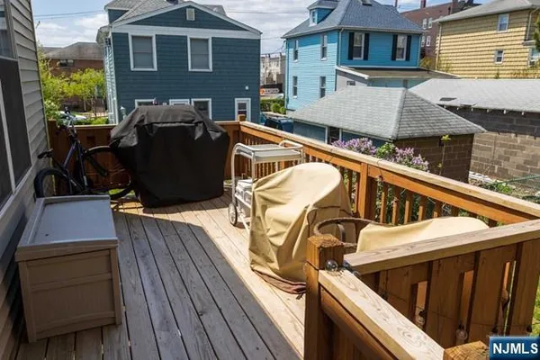 a view of a patio with table and chairs a barbeque with wooden floor and fence