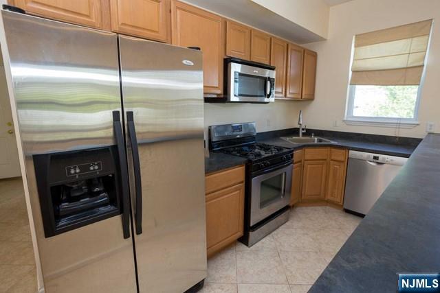 199 Van Winkle Street, Unit 2 East Rutherford, NJ 07073 - Photo 6 of 22 a kitchen with stainless steel appliances granite countertop a stove a microwave and a refrigerator
