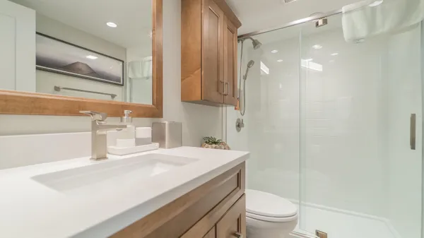 a bathroom with a sink a toilet and shower