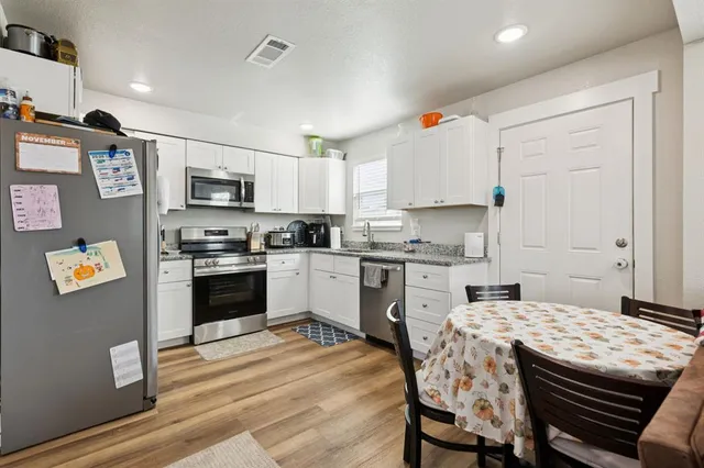 a kitchen with stainless steel appliances granite countertop a refrigerator stove and sink